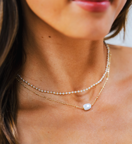Model wearing  a stack of moonstone necklaces