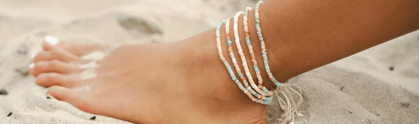 Woman wearing women's anklet on both feet. Dainty gold anklet on and a dainty silver anklet on the other food. Master Healer healing energy stone anklet.