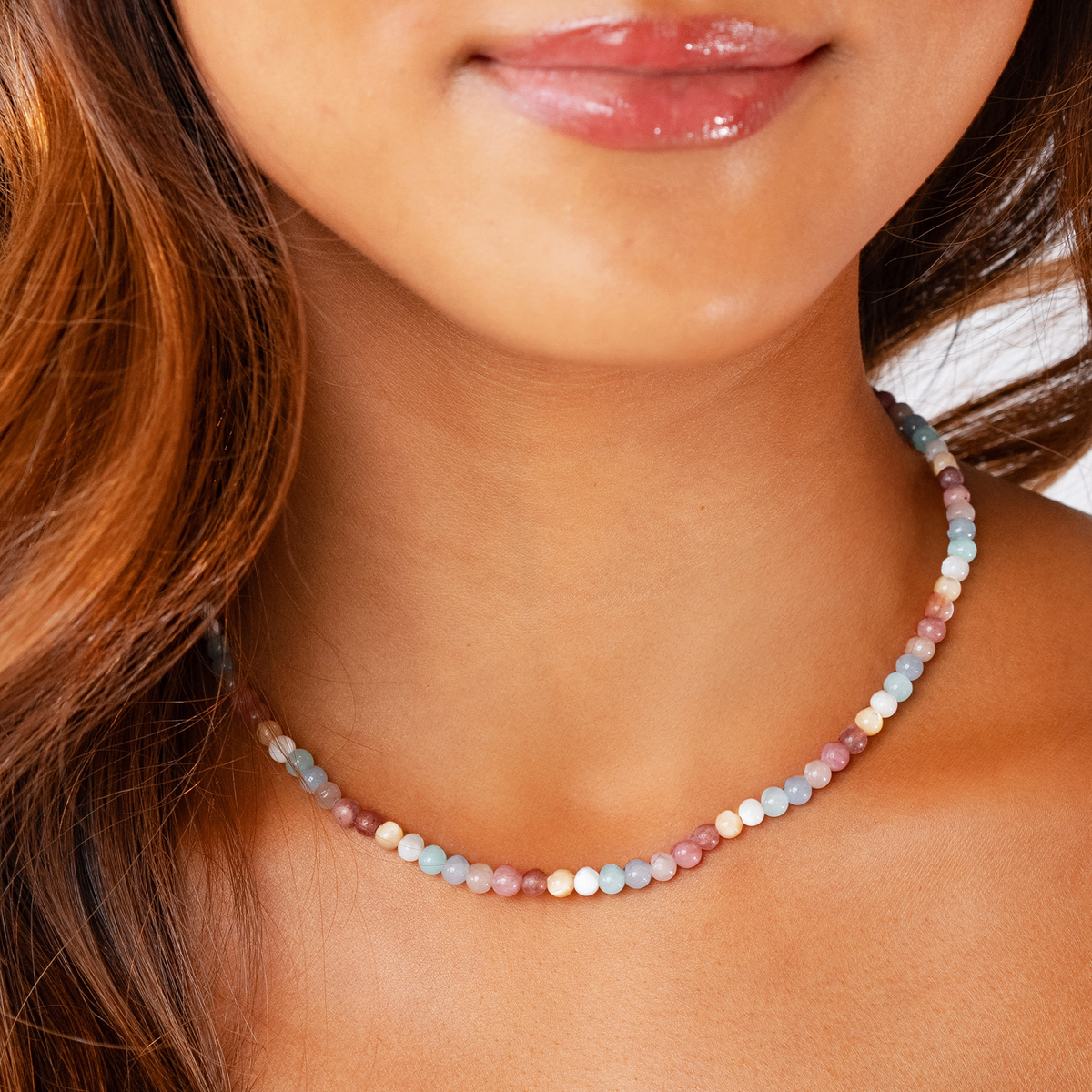 Model wearing a 4mm blue, white, and pink stone healing necklace