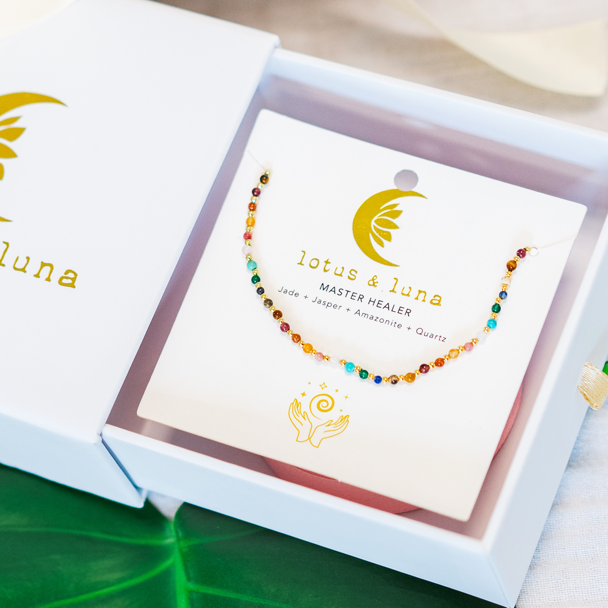Dainty necklace with assorted multi-color stones and gold beads on packaging