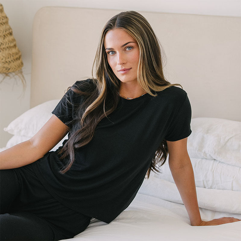 Black Daily Tee, reclining on bed
