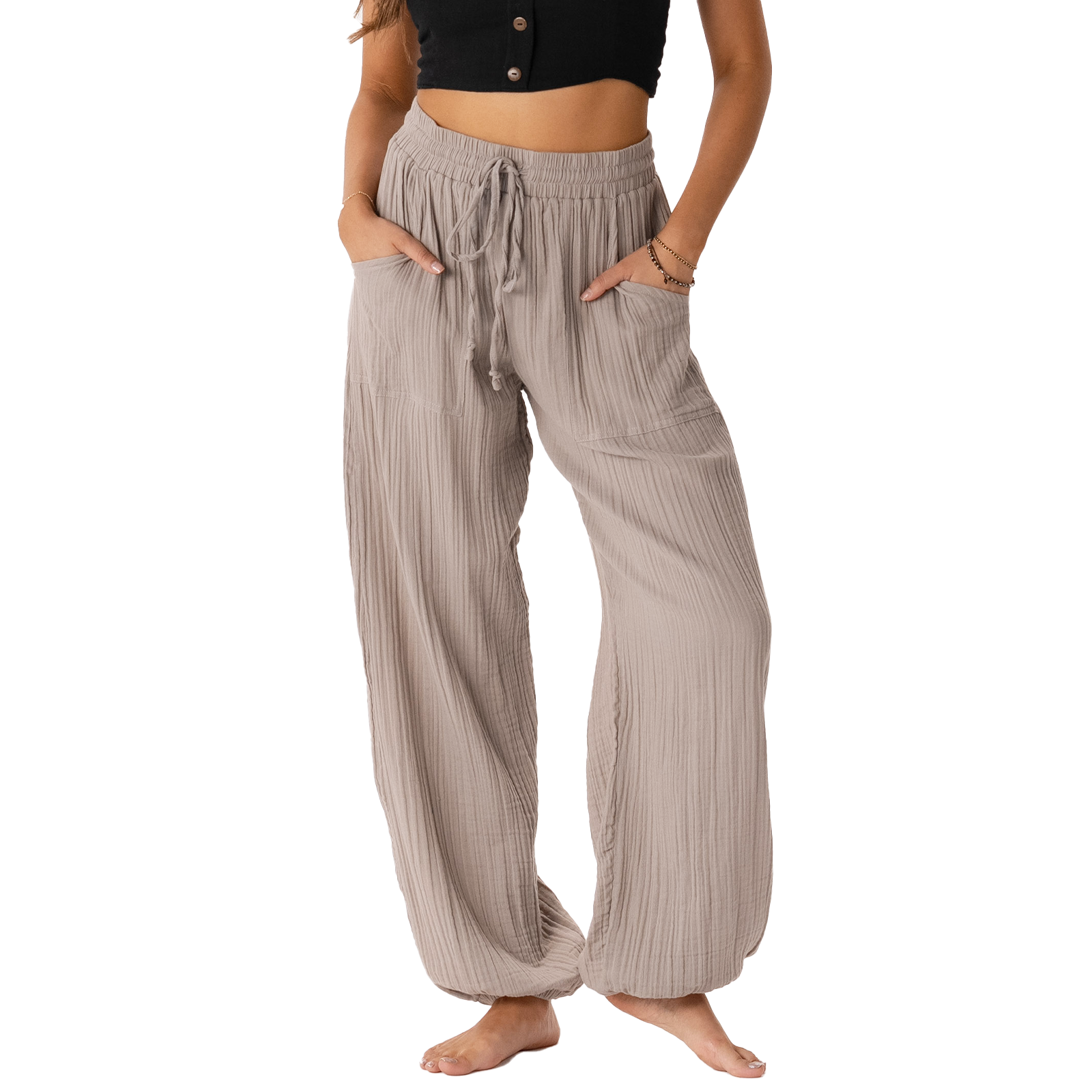 Model wearing stone colored harem pants with a drawstring waistband