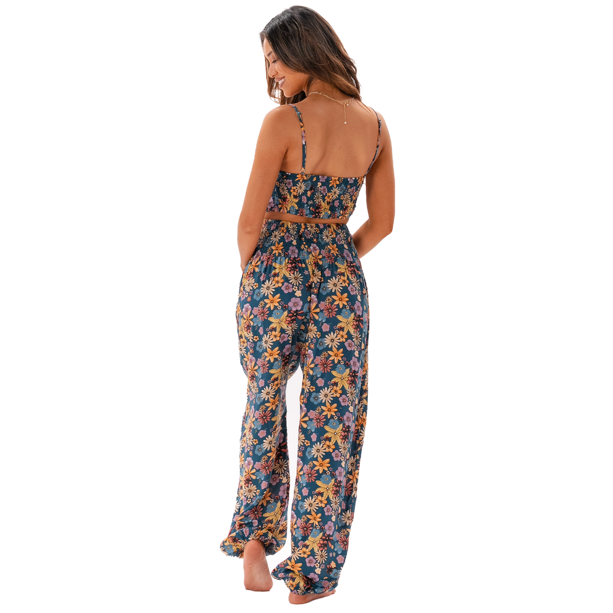 Model wearing blue, pink, orange and yellow floral print harem pants and a matching tank top