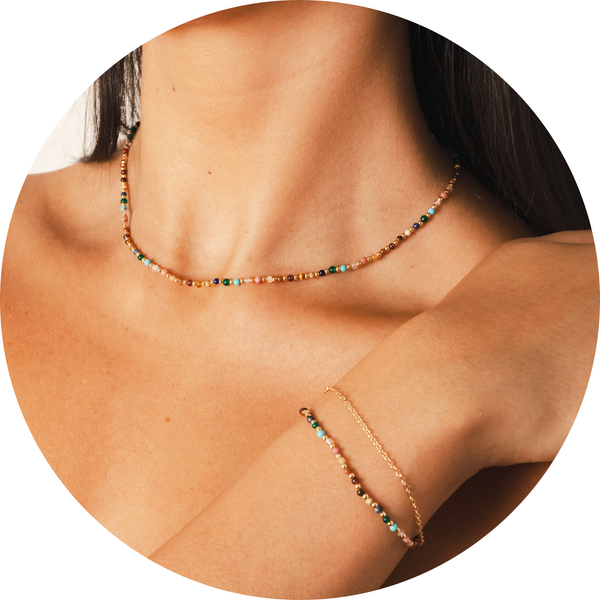 Model wearing a matching healing bracelet and necklace set. The set includes a 2mm multicolor stone and gold stone healing necklace and  2mm multicolor stone and gold bead healing bracelet with an attached dainty gold chain 