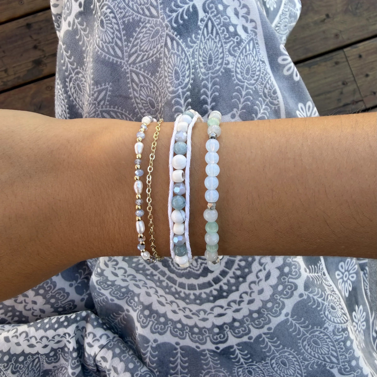 Crystal Waters Healing Bracelet, stacked on wrist with gray skirt