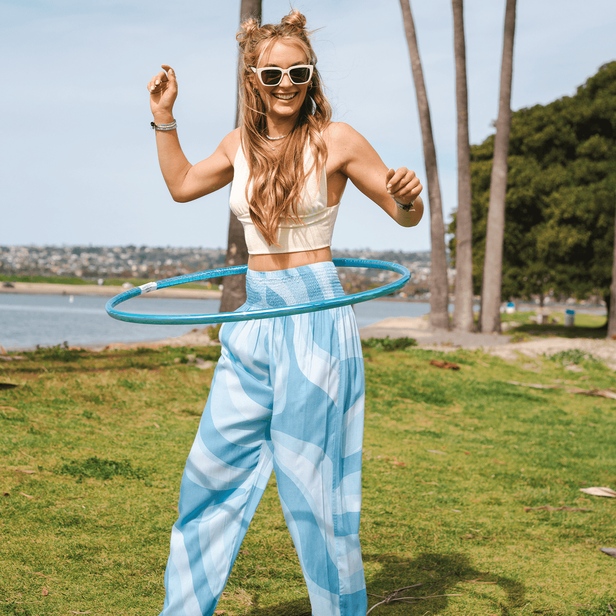 Model hula hooping while wearing blue swirl harem pants