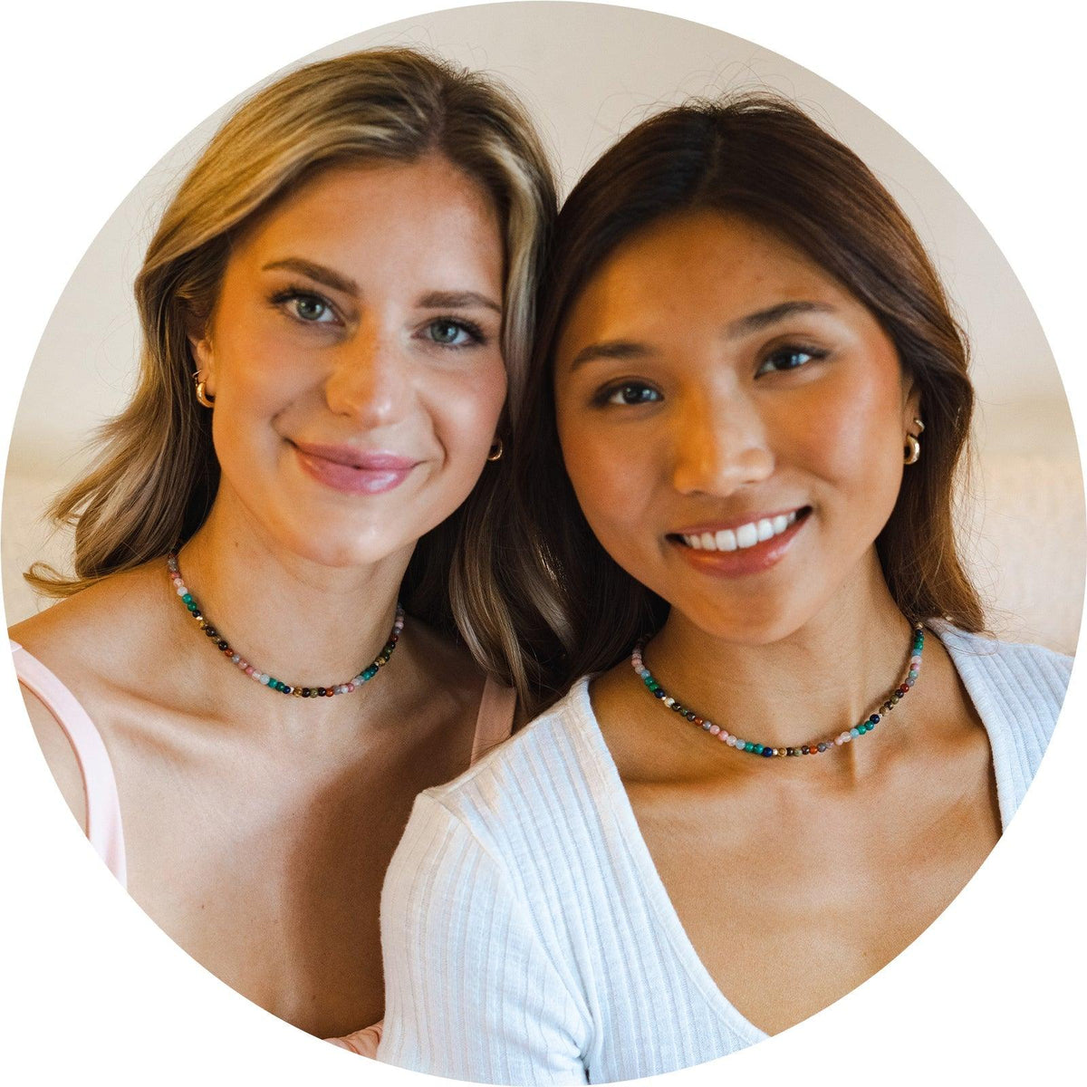 Two girls wearing matching healing necklaces. The necklace is a 6mm multicolor stone healing necklace