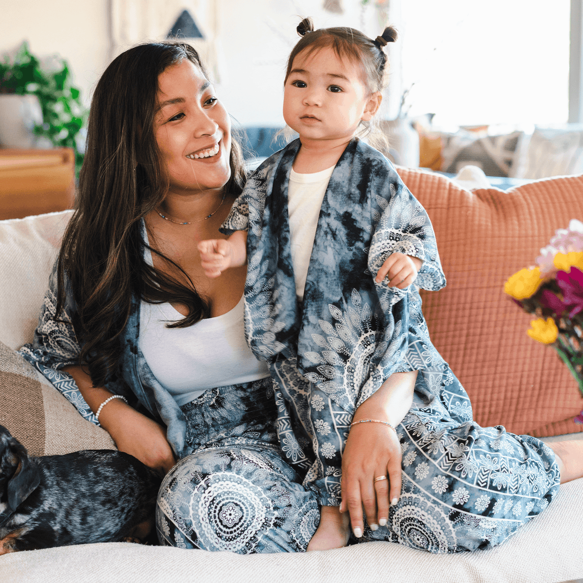 Baby and mom wearing matching grey watercolor lounge sets with white mandala prints. These sets include a kimono and harem pants 